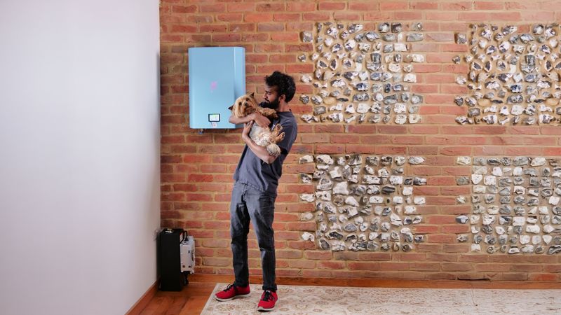Photo of a man holding a dog while stood next to a Bolt e-boiler
