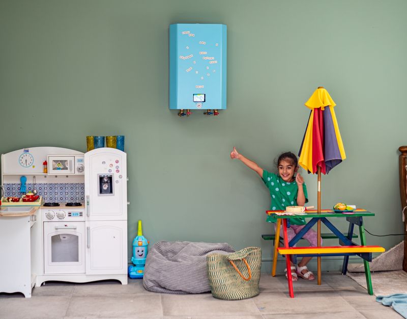 Photo of a girl playing with her toys alongside a wall-mounted Bolt e-boiler